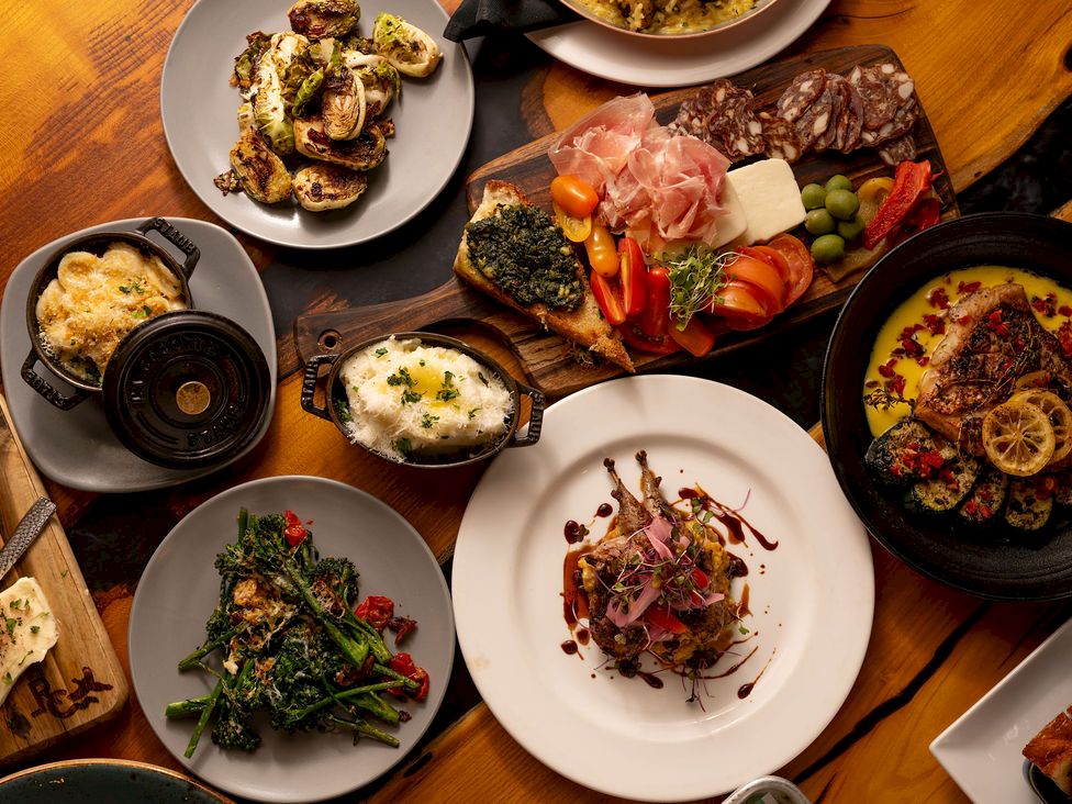 A gourmet spread of meats, seafood, roast vegetables, eggs, and bread on wooden boards&mdash;ready to eat tonight.
