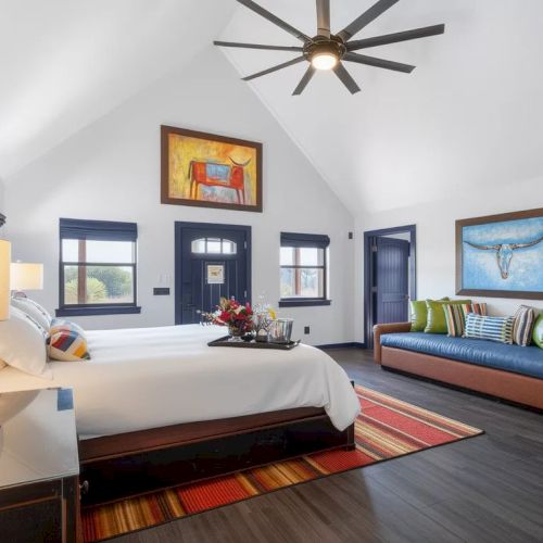 A cozy, creative classroom/galley with a desk, hanging papers, colorful shelves, a globe, and student projects on the walls, end.