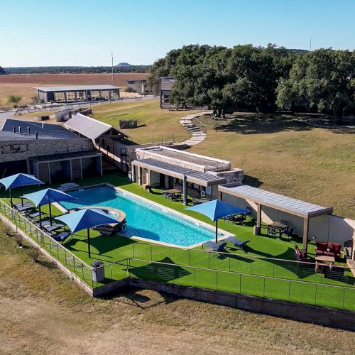 A bright green toy car with blue accents drives on a dirt track, engines roosting dust as spectators watch the race.