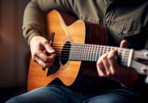 A person is playing an acoustic guitar, focusing on strumming the strings and creating music with their hands on the instrument.