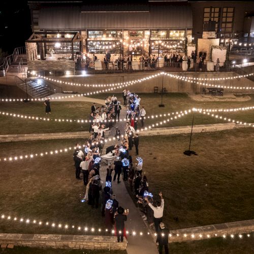 A nighttime street scene with a motorbike parked on a cordoned-off area, bright lights and people in the background, caution tape across the area.