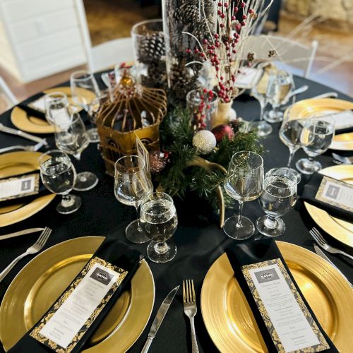 A formal dining table set with yellow napkins, white plates, silverware, and a floral centerpiece.
