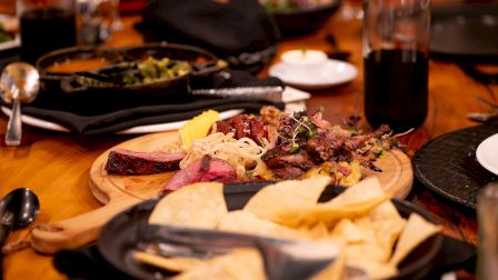A festive table with assorted tapas and colorful dishes, bread, dips, and drinks, inviting a cozy, communal meal to share tonight.
