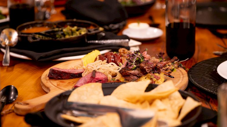 A festive table with assorted tapas and colorful dishes, bread, dips, and drinks, inviting a cozy, communal meal to share tonight.